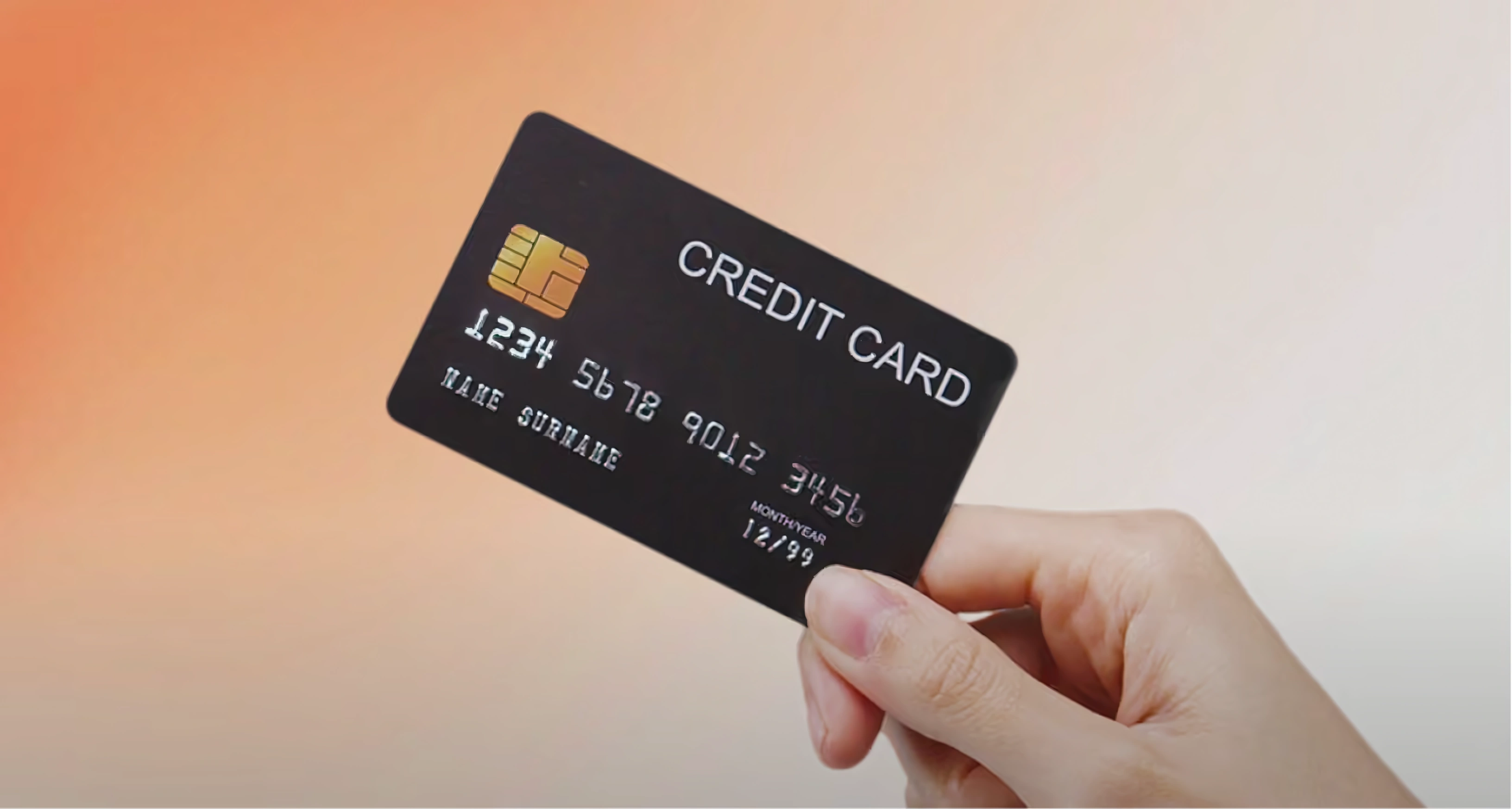 Mano sostiene una tarjeta de crédito con chip.