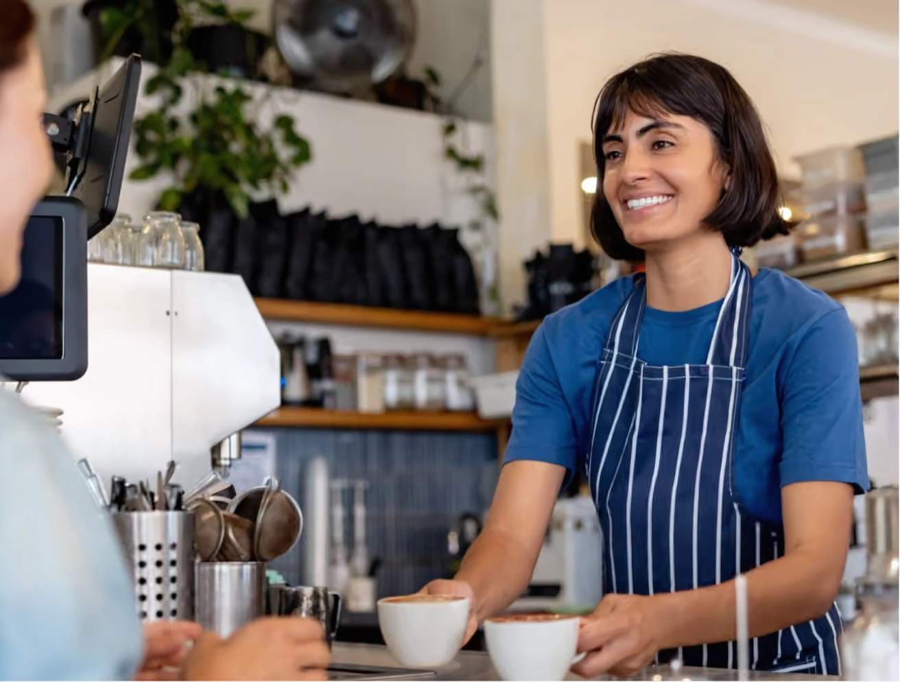 Comerciante atiende a una clienta en una cafetería.