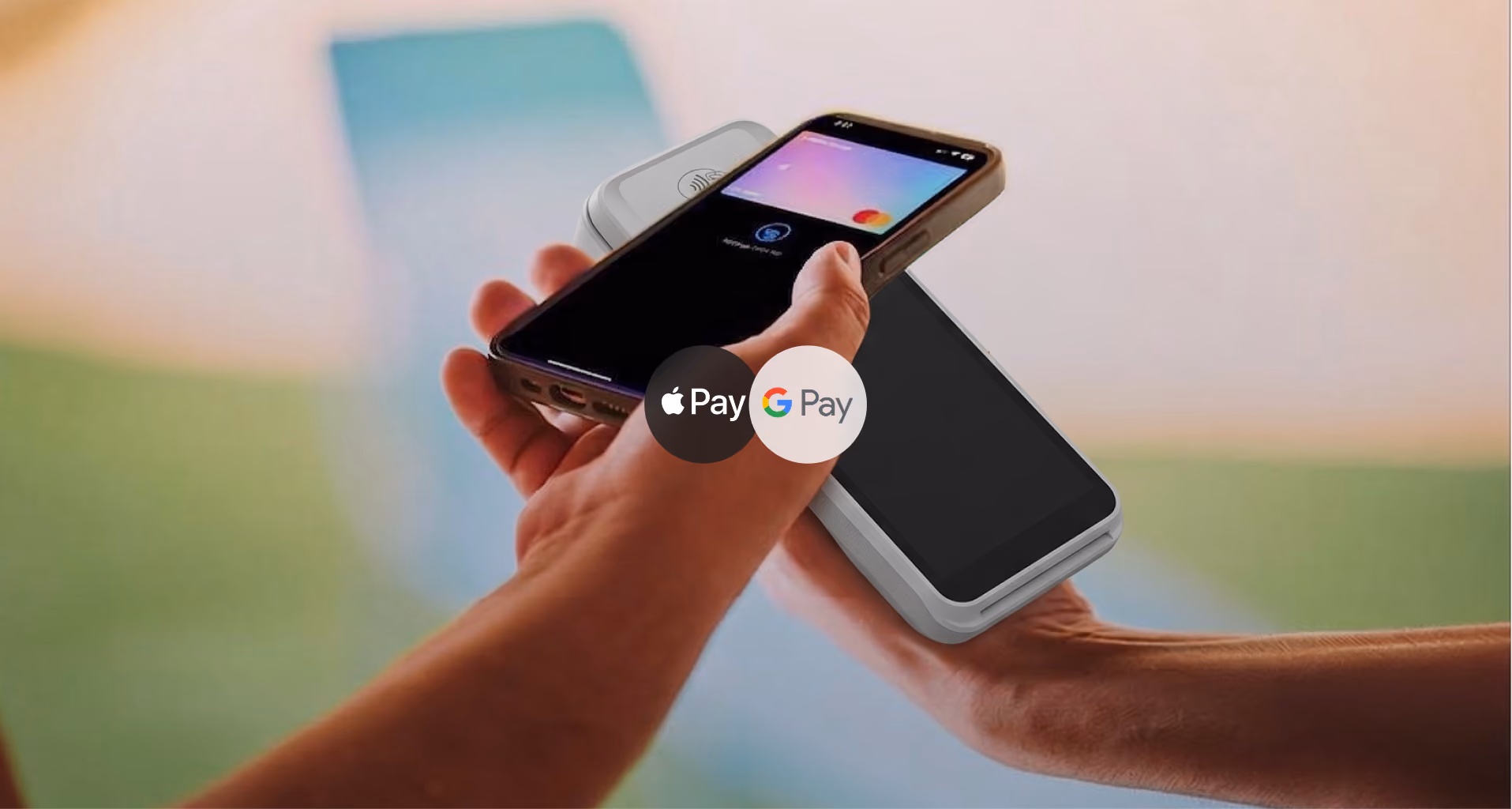 Una mano sostiene un teléfono inteligente que está realizando un pago sin contacto con un dispositivo de punto de venta, mostrando los botones de Apple Pay y Google Pay en pantalla.