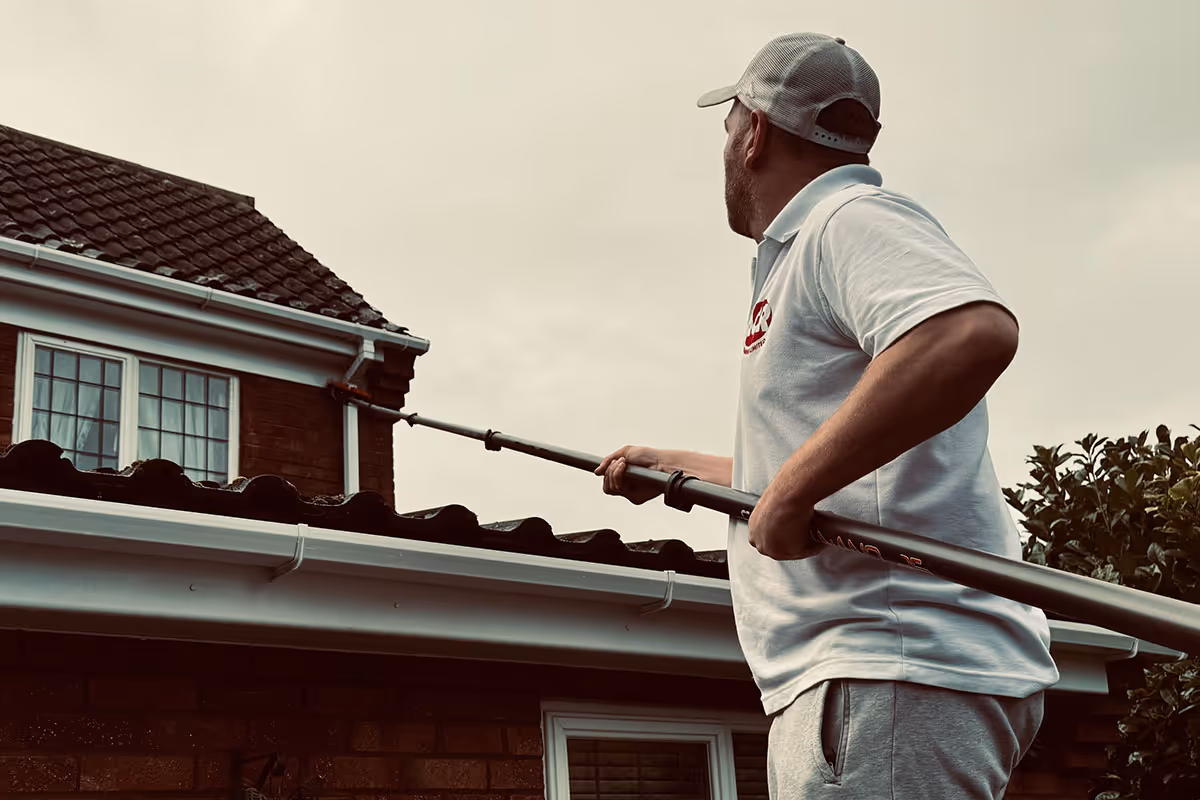 ACR Cleaning Ltd technician is cleaning residential windows using a water-fed pole.