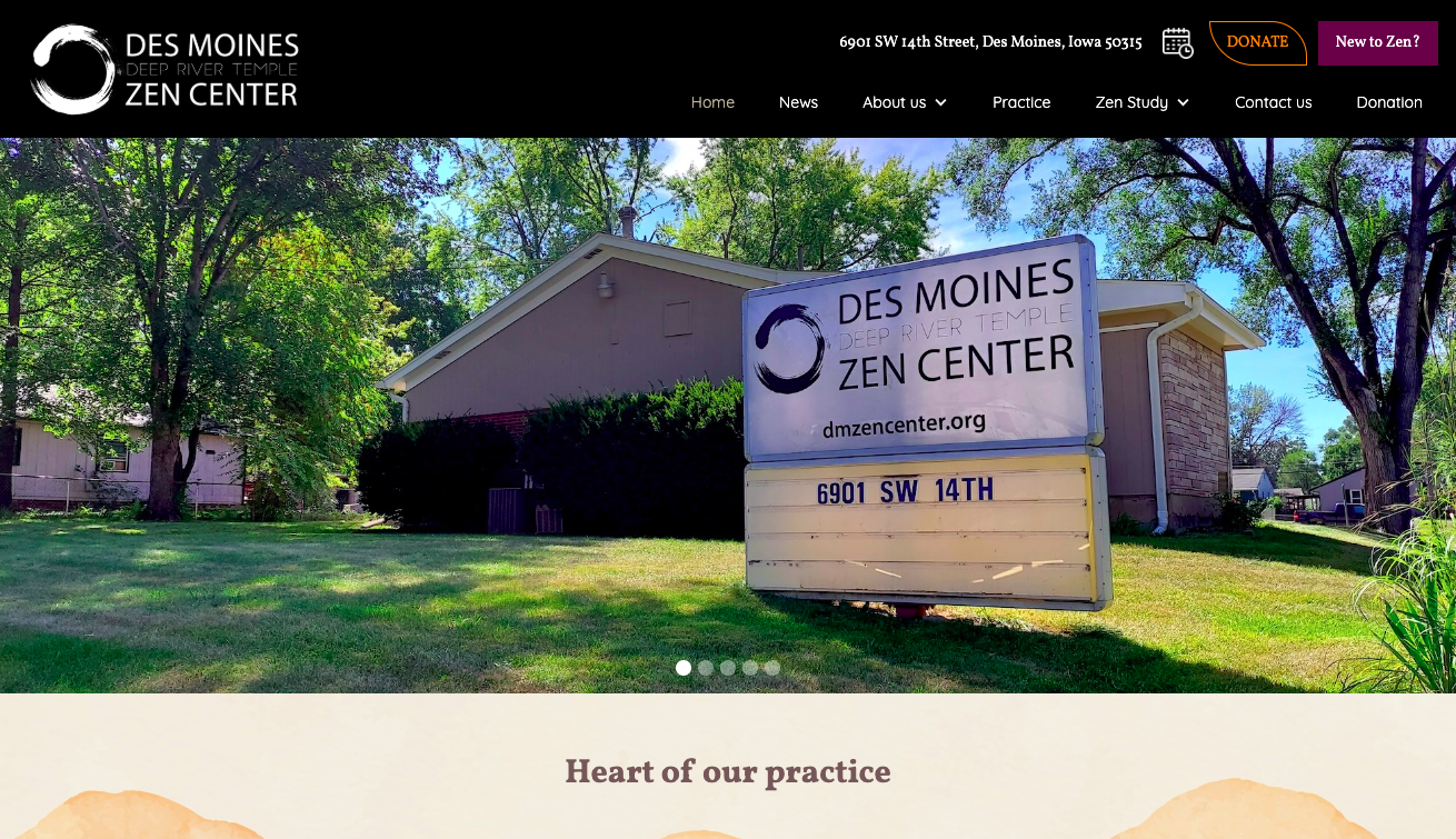 Outdoor sign for Des Moines Deep River Temple Zen Center with building and trees in background under blue sky.