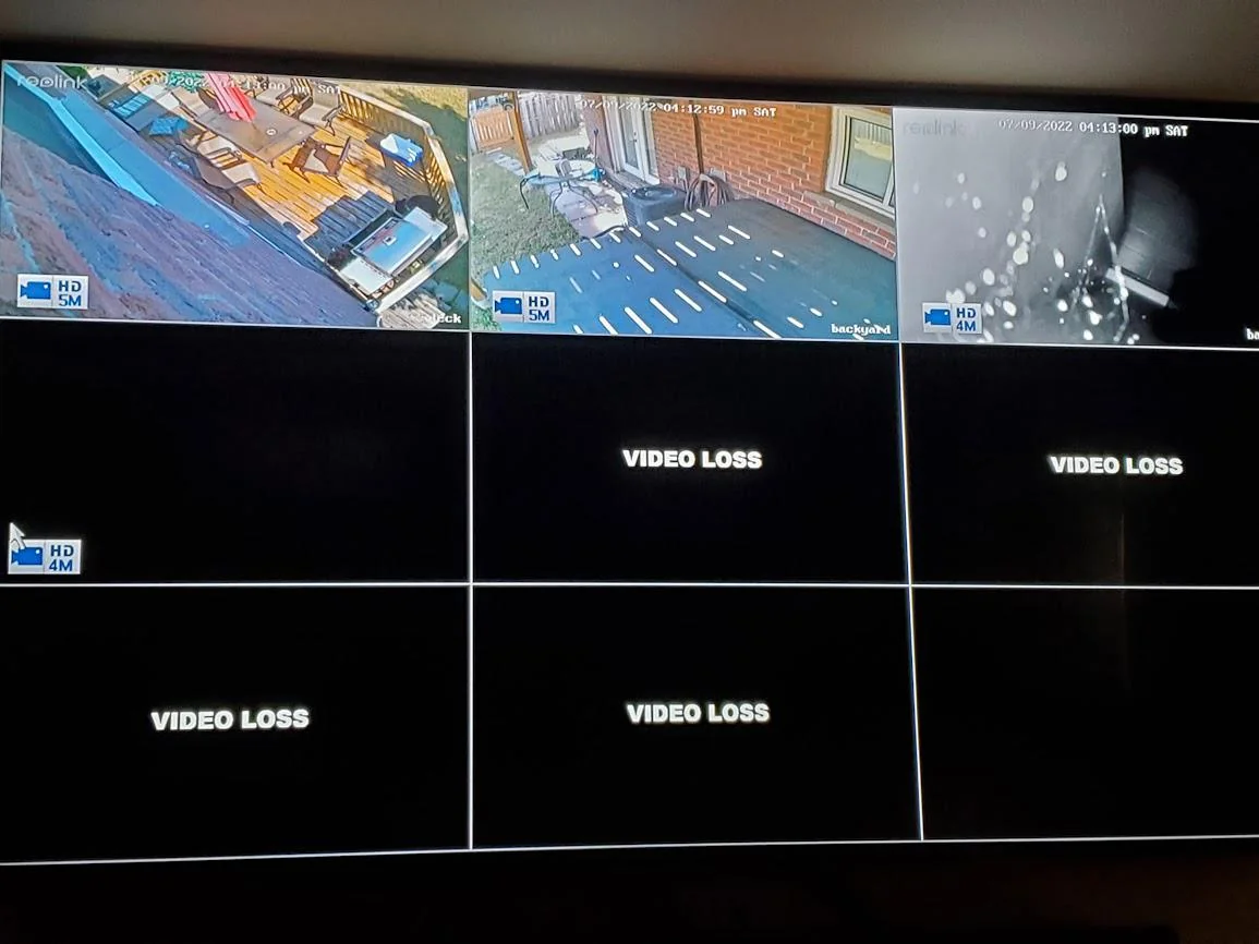 Security camera monitor displaying nine surveillance feeds: three active with outdoor views of a deck, backyard, and close-up with water droplets, six feeds showing black screens with 'VIDEO LOSS' text indicating signal loss.