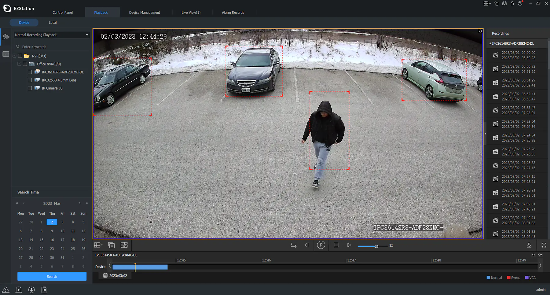 Security camera playback interface showing a parking lot with three cars and one person walking, each outlined with red detection boxes, timestamped 02/03/2023 12:44:29.