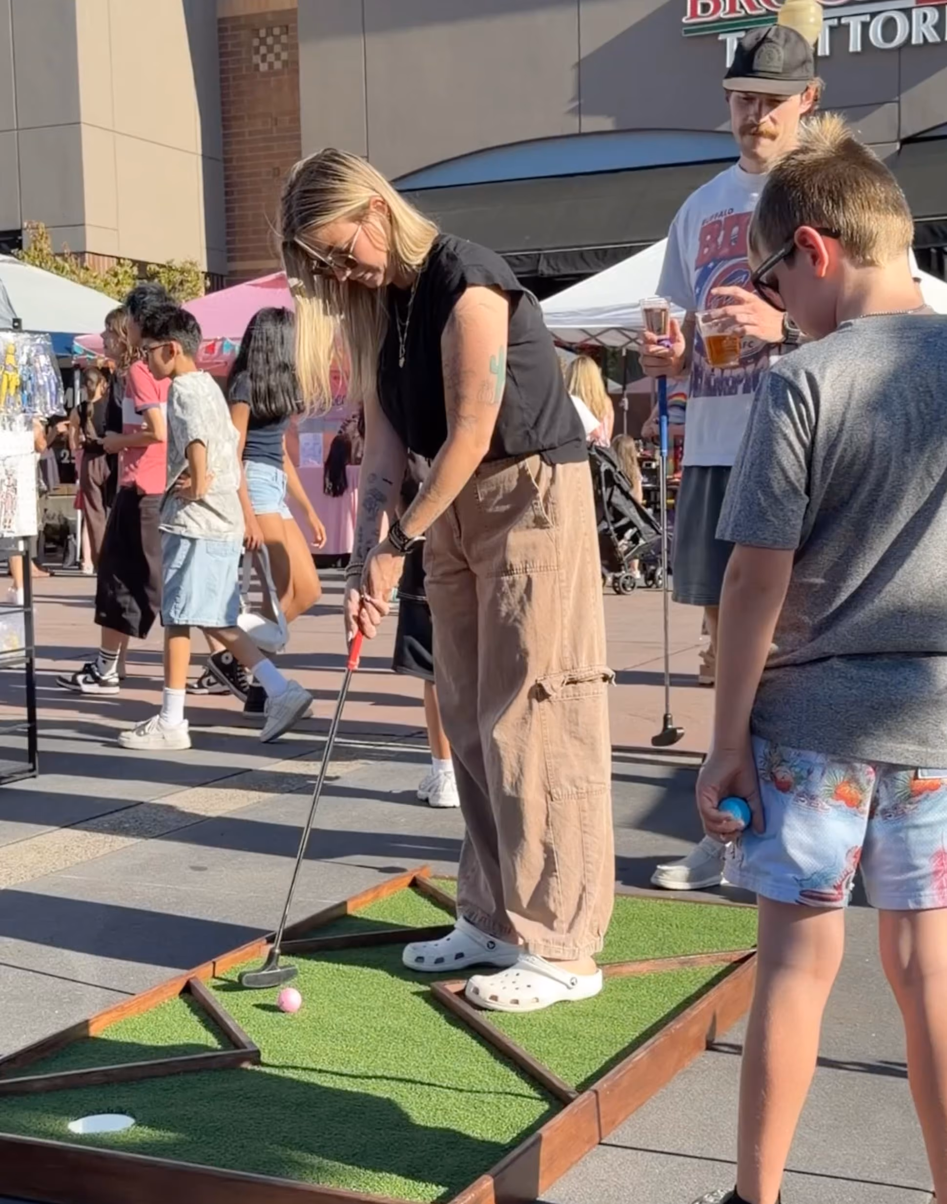 Woman playing mini golf at an outdoor community event