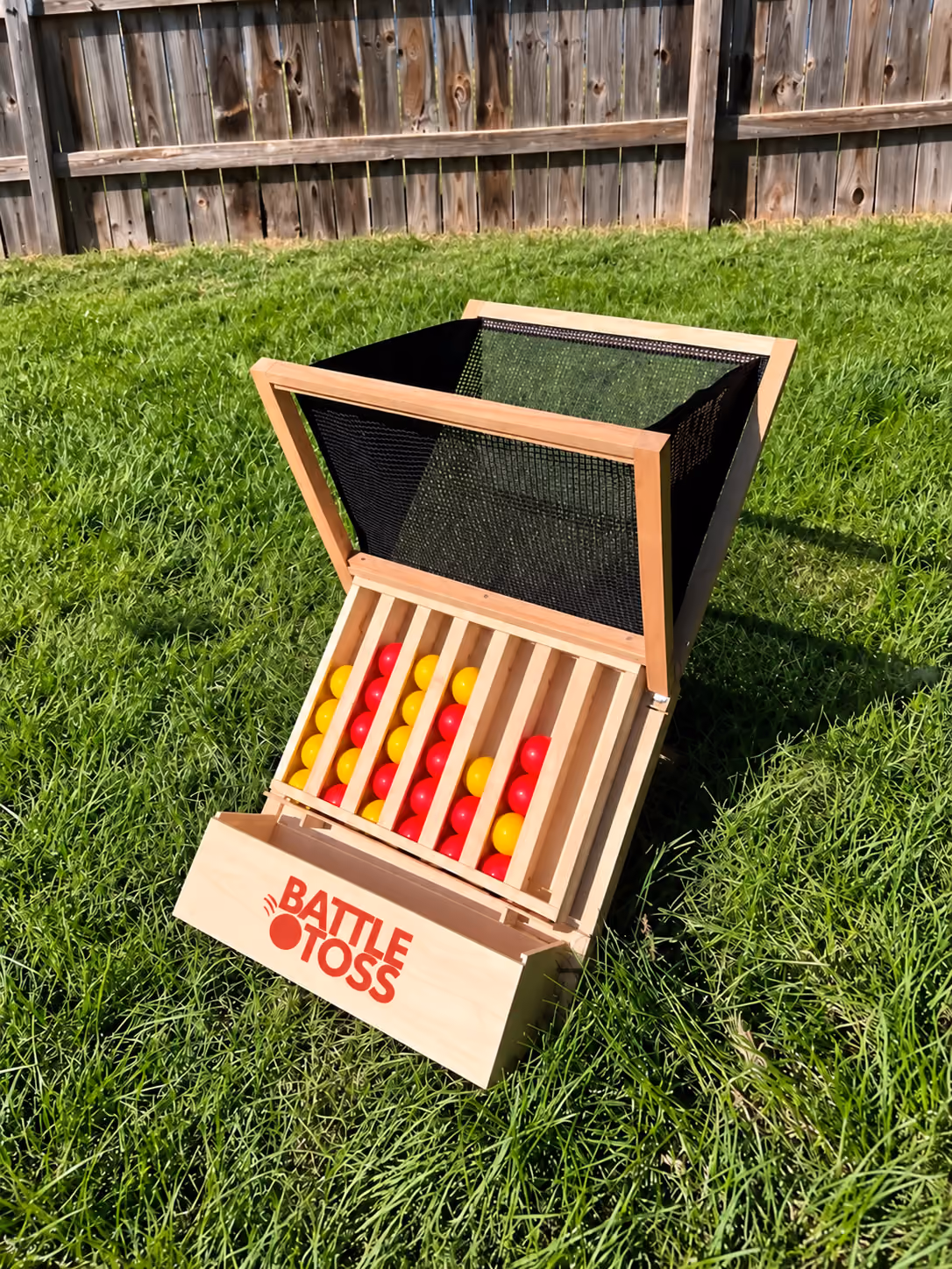 Battle Toss yard game with a wooden frame, mesh basket, and red and yellow balls.