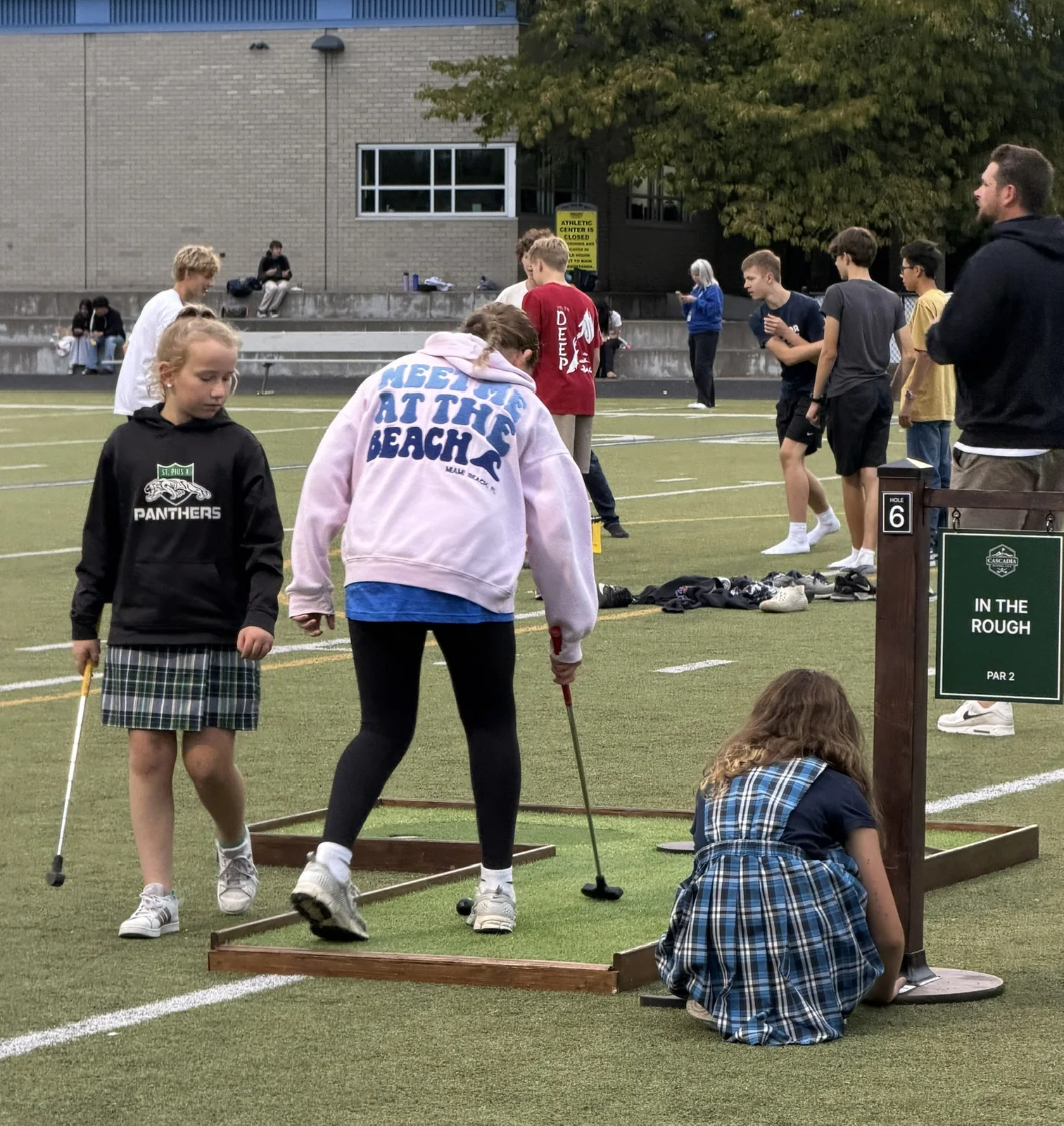 Players taking turns on a mini golf hole at Valley Catholic's homecoming carnival