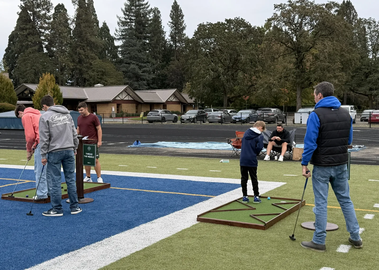 Students playing adjacent mini golf holes on Valley Catholic's athletic field