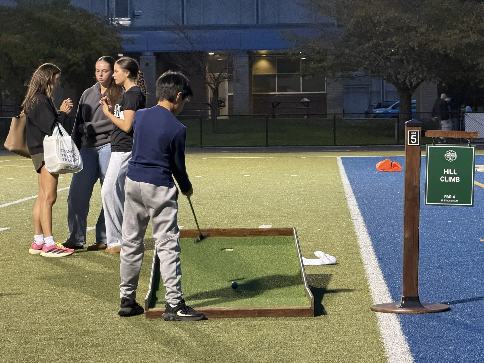 Students watching a friend putt at Valley Catholic's homecoming carnival