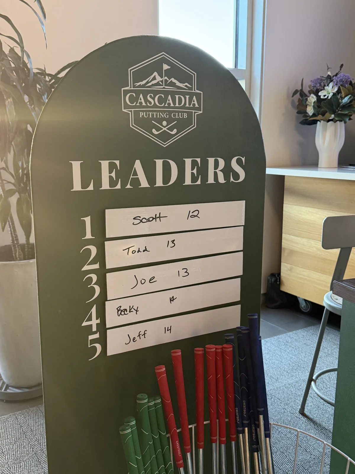 Mini golf leaderboard and putters inside REX HILL winery