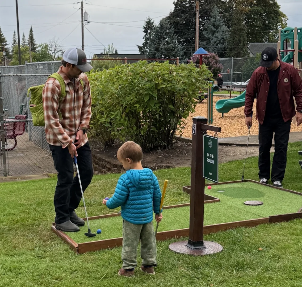 Adult and child playing a mini golf hole together at Carlton Crush