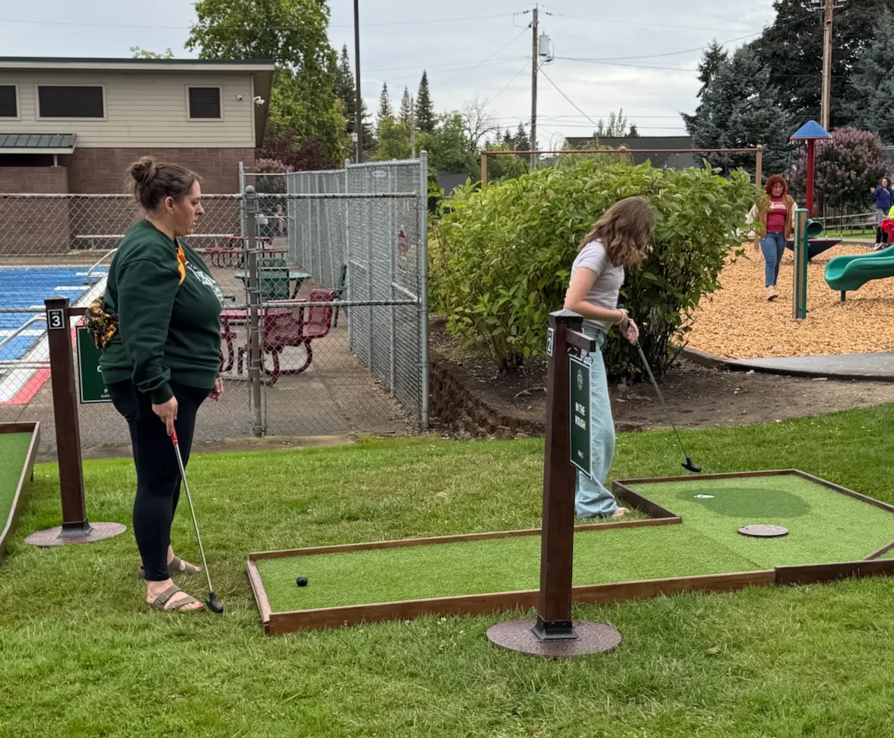 Guests playing a mini golf hole with white rock obstacles at Carlton Crush