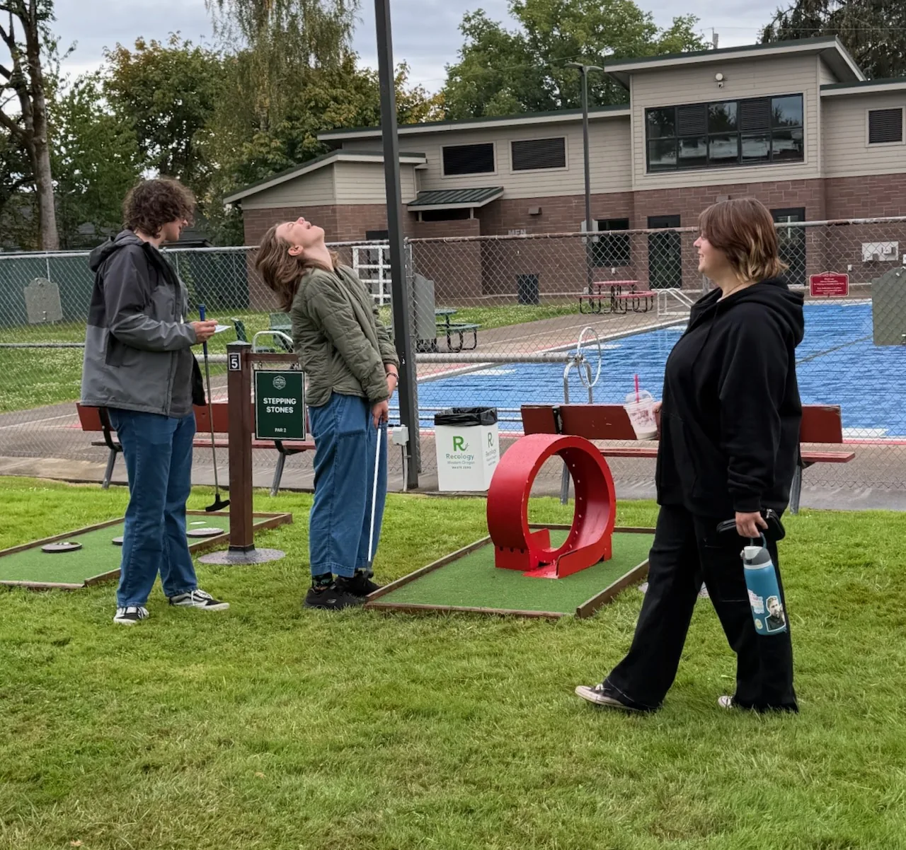 Guests beside the red loop mini golf obstacle at Carlton Crush