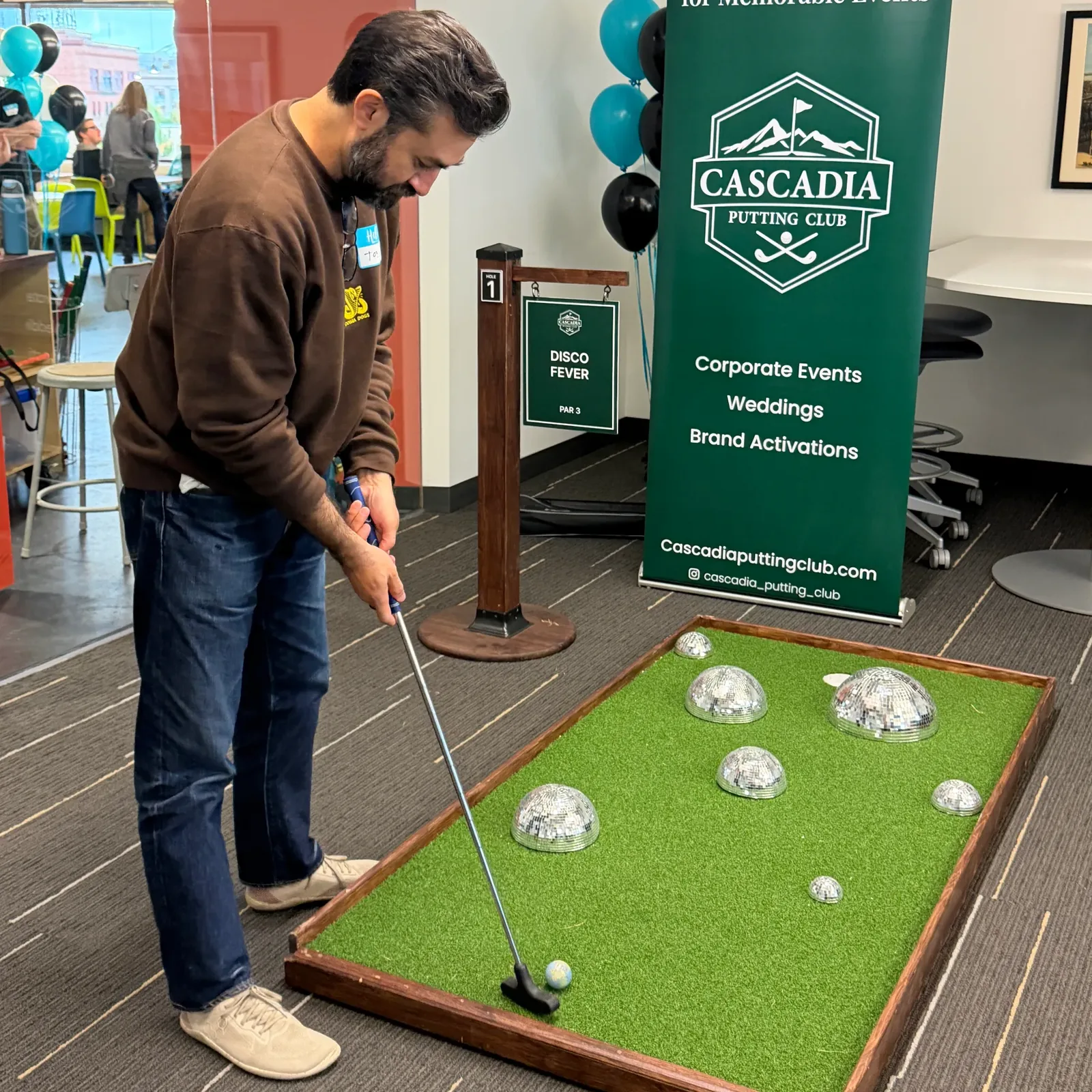 Guest putting between white rock obstacles at UpStart Collective's anniversary party