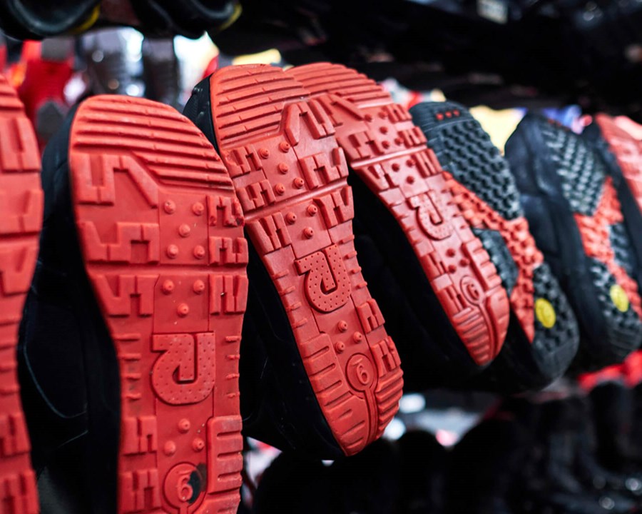 Multiple pairs of snowboarding boots hung up.