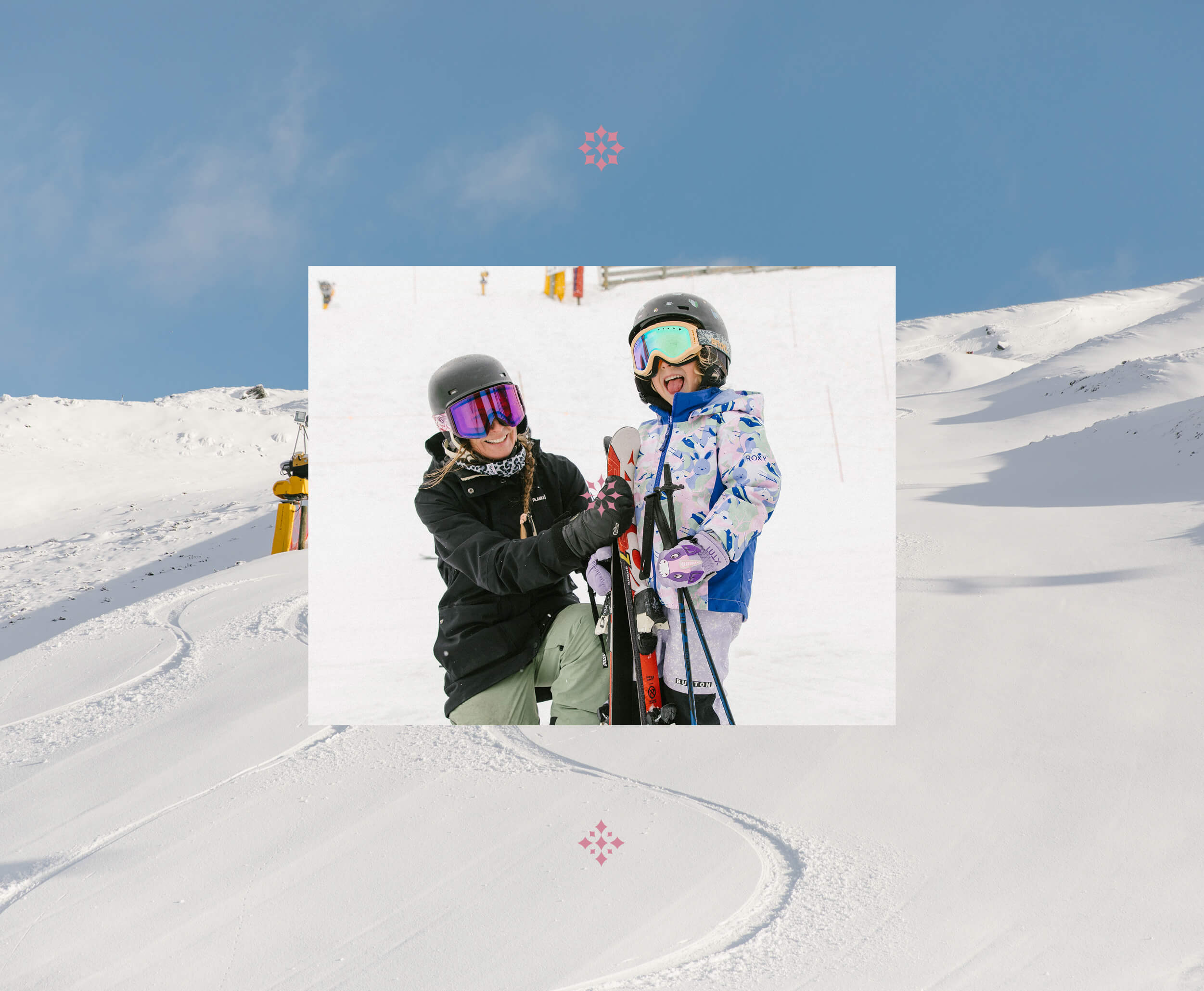 Adult and child in ski gear smiling on snow, child playfully sticking out tongue.