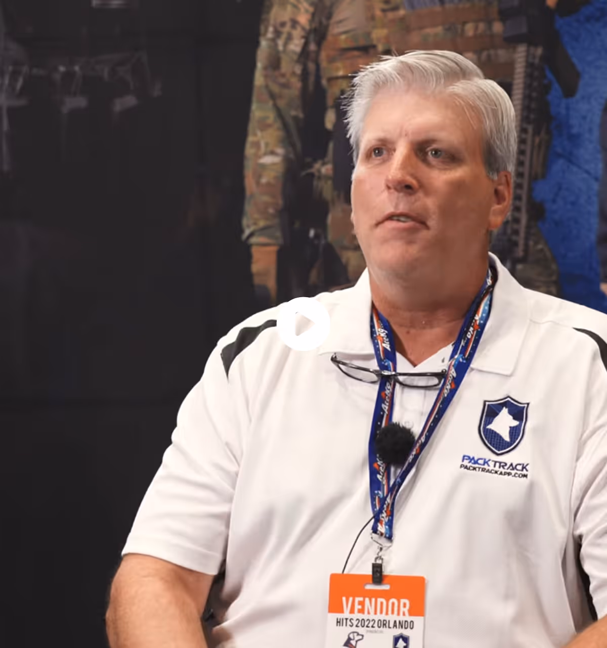 Man with gray hair wearing a white PackTrack polo and vendor badge at HITS 2022 Orlando event.