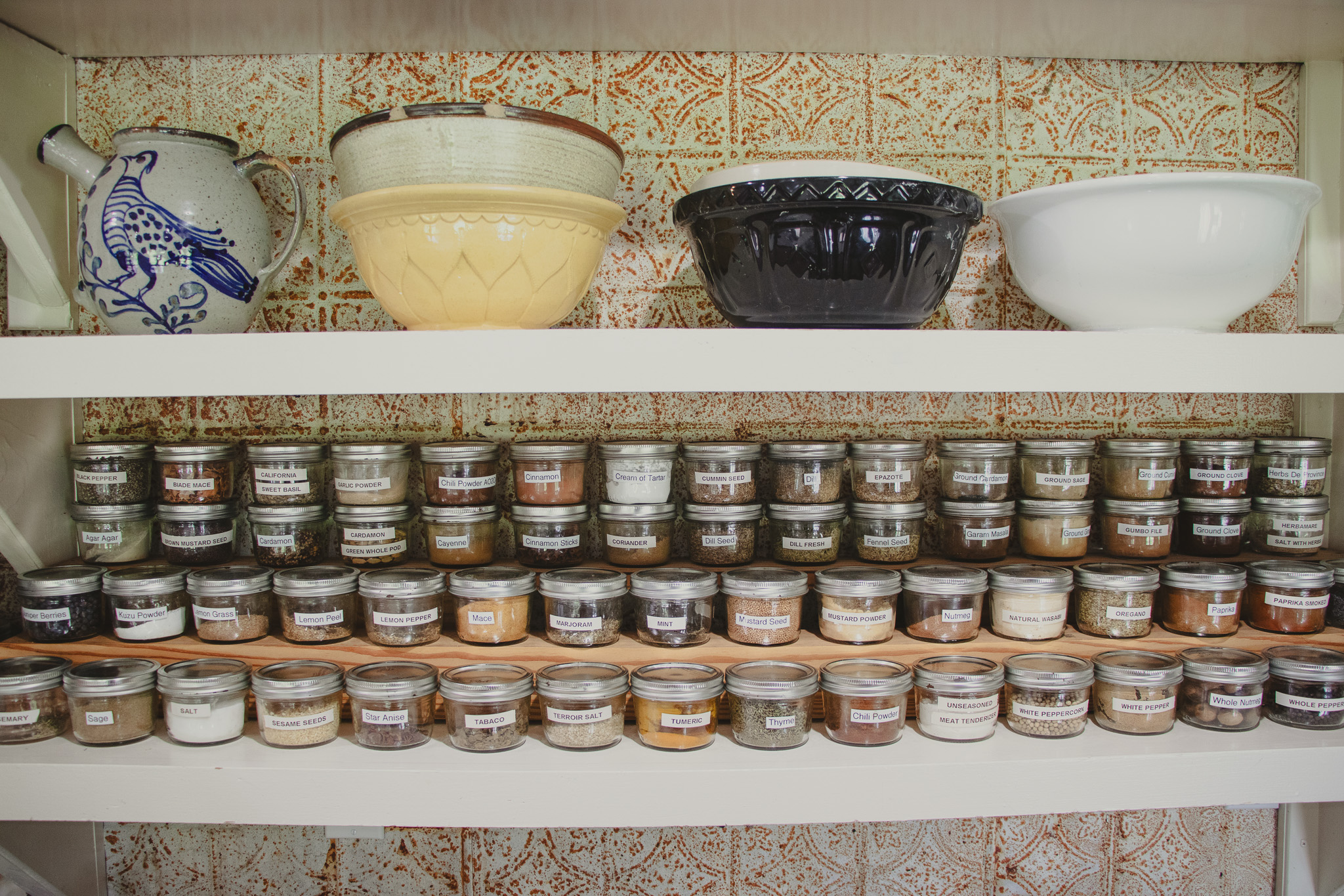Close-up of two pantry shelves against the same orange patterned tile