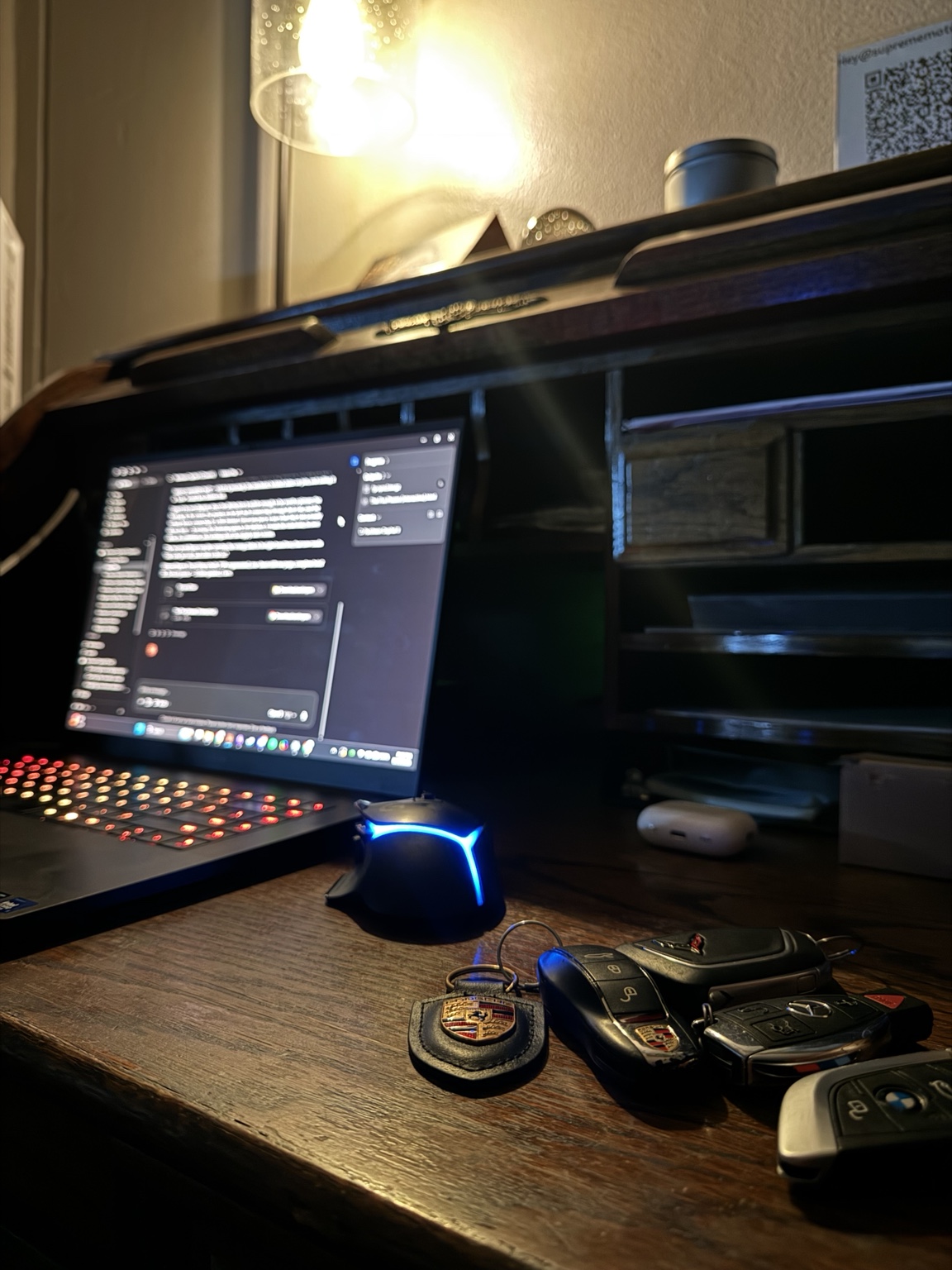 A laptop and a set of exotic car keys at night, the AI systems Ken Van Vorhis uses to run Prometheus Exotics