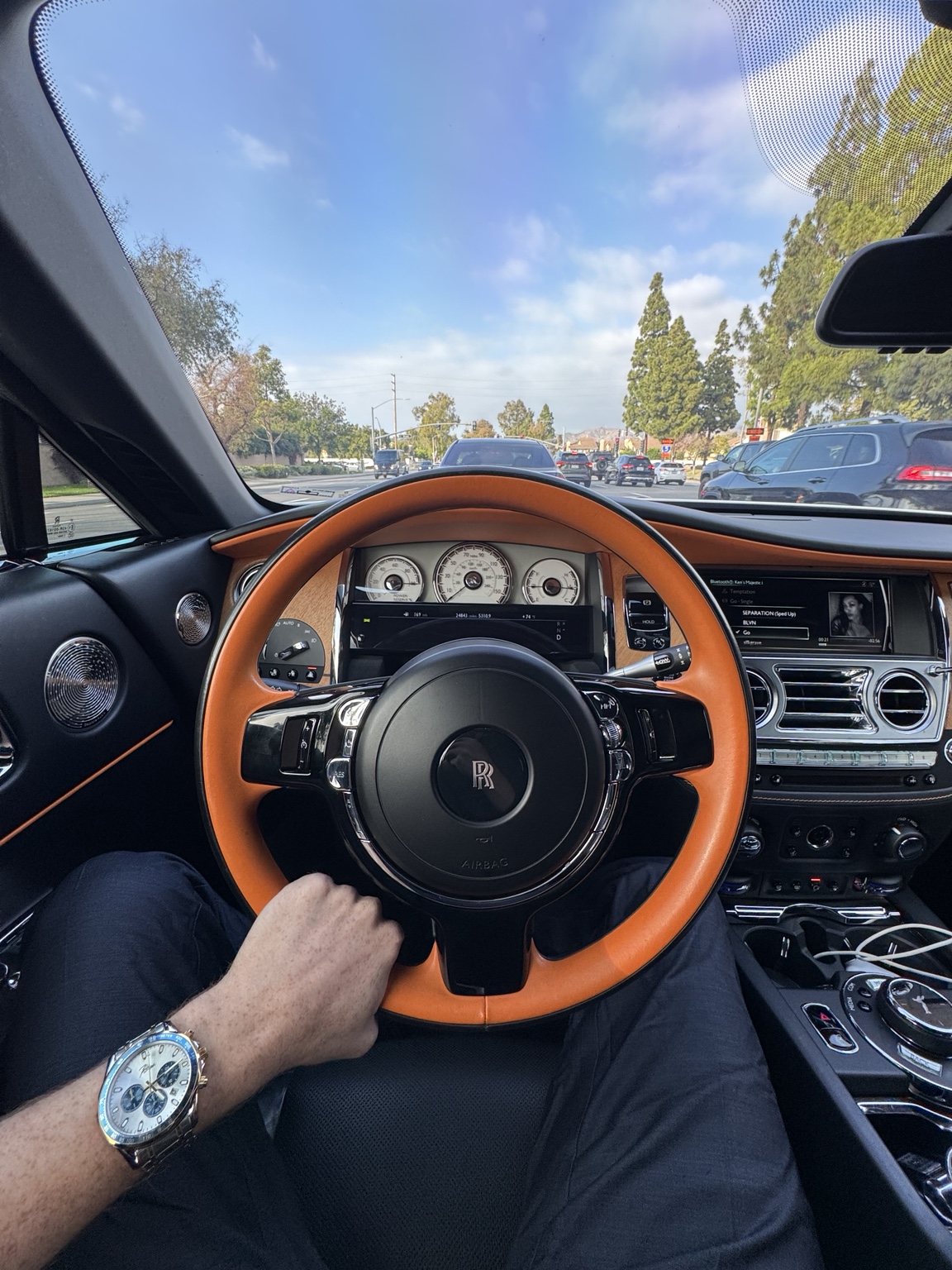 Ken Van Vorhis at the wheel of a Rolls-Royce with tan leather interior, parked in Orange County, California