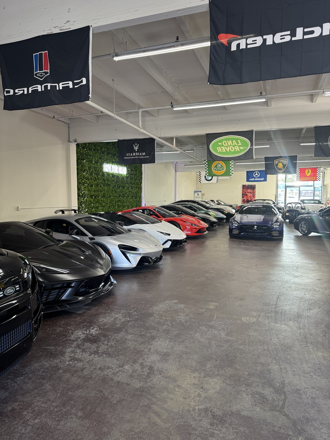 The Southern California warehouse where the Prometheus Exotics fleet is kept, lined with McLaren, Lamborghini, Ferrari and Land Rover flags