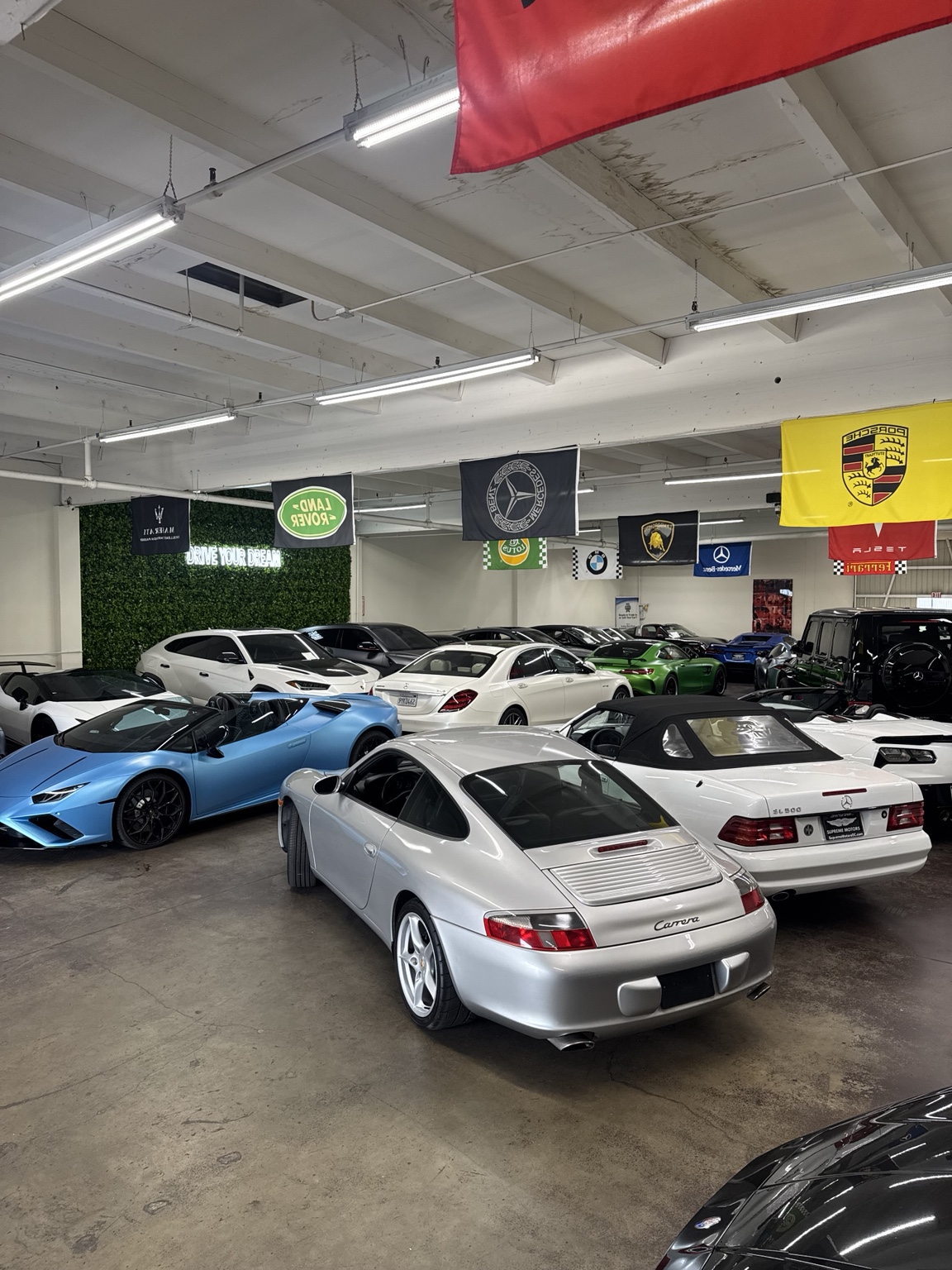 A Porsche 911 and a blue Lamborghini Huracan among the cars kept in the Prometheus Exotics warehouse