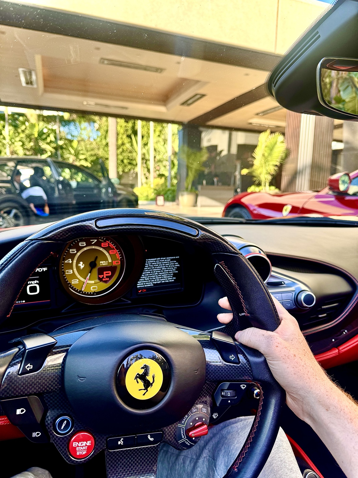 Behind the wheel of a Ferrari at a hotel entrance in Southern California