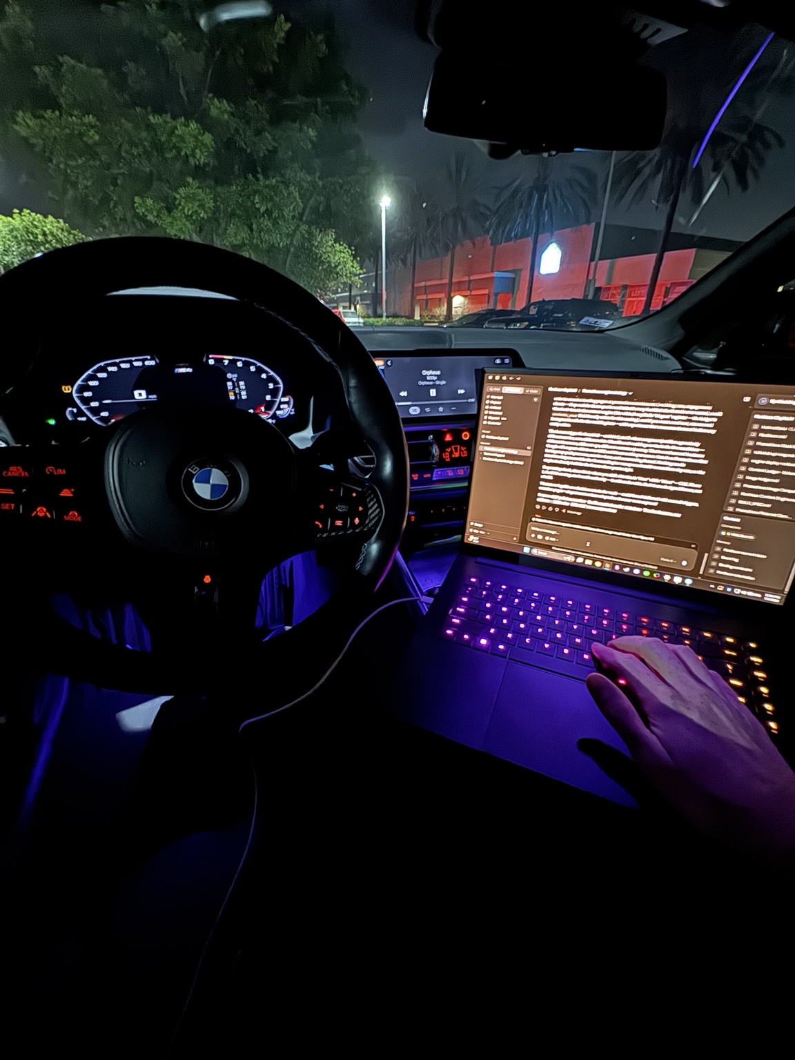 Ken Van Vorhis working on a laptop in the front seat of his BMW at night, running Prometheus Exotics from the car