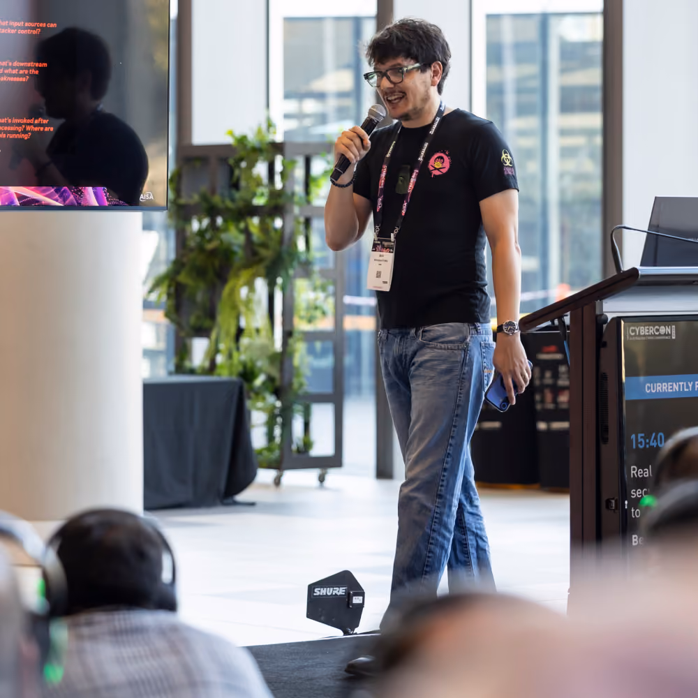 Speaker addressing the audience with a microphone at a CyberCon session