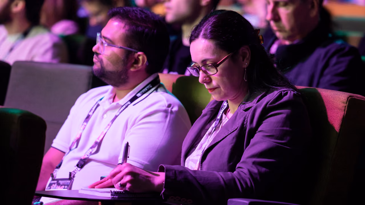 Delegates taking notes during a CyberCon conference session