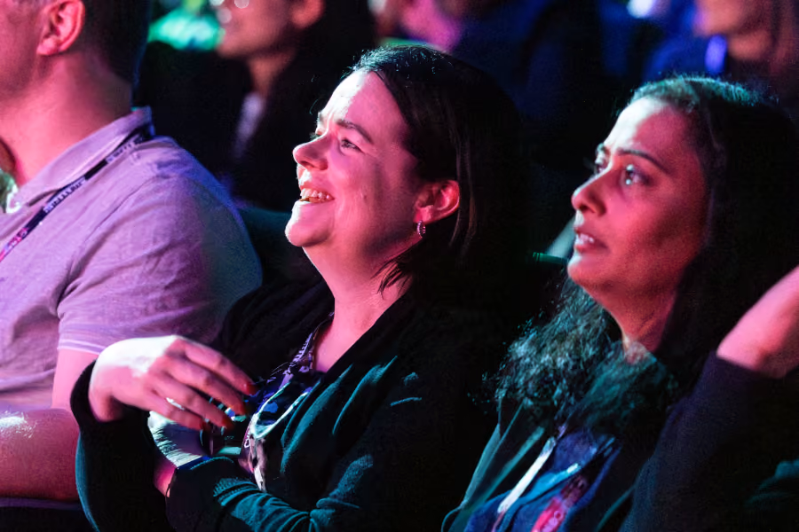 Delegates watching the screen under coloured lighting at CyberCon movie night