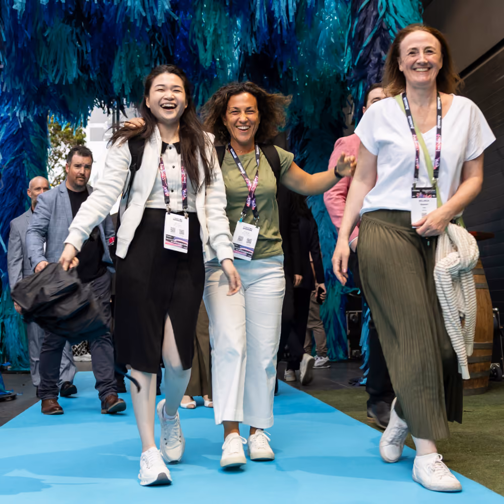 Delegates laughing as they walk the blue carpet at a CyberCon event