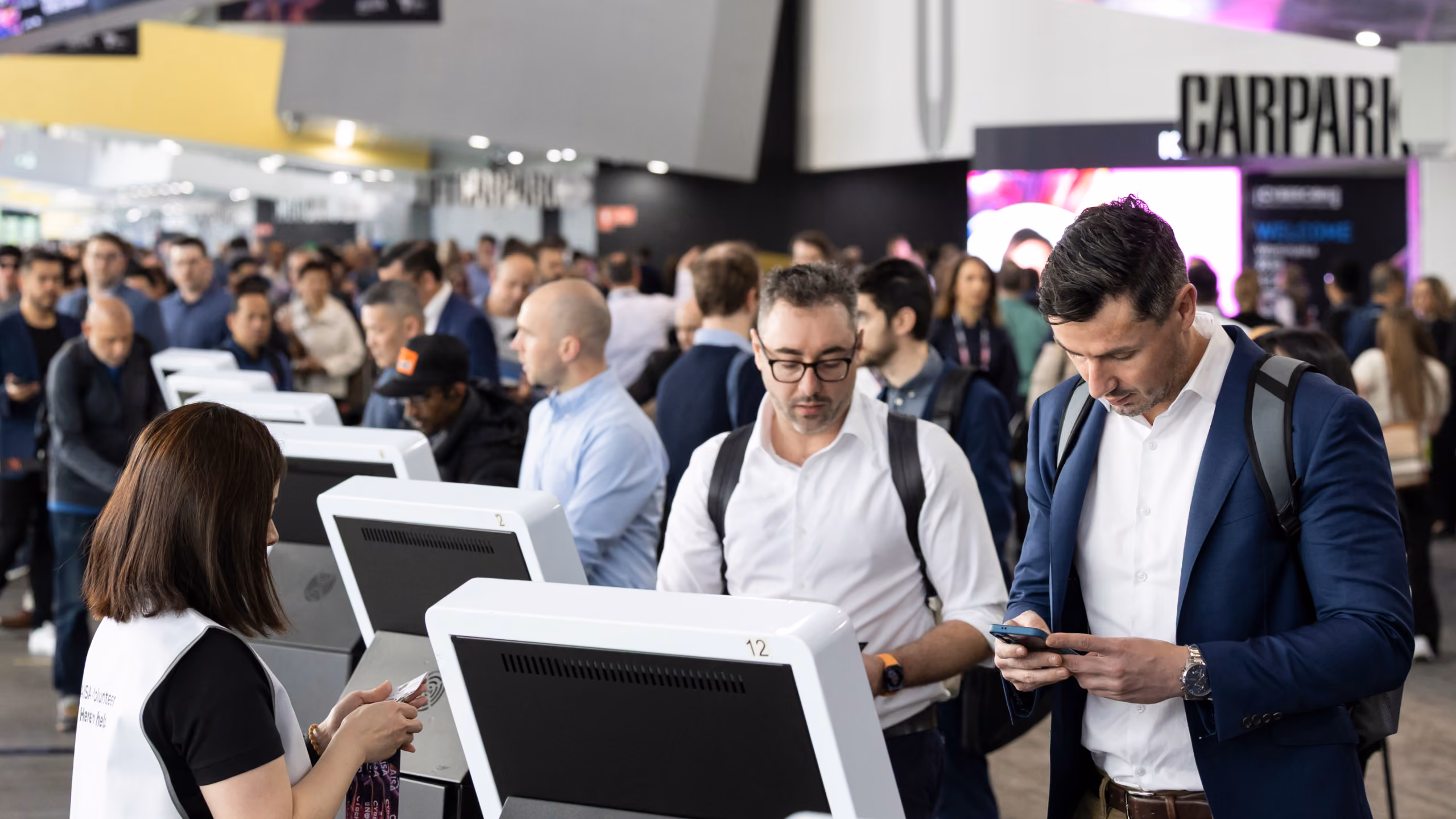 Delegates checking in at self-service registration kiosks at CyberCon