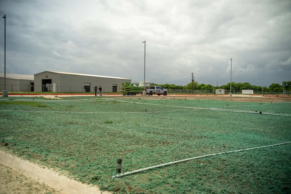 Completed hydroseeding project beside commercial facility in North Texas