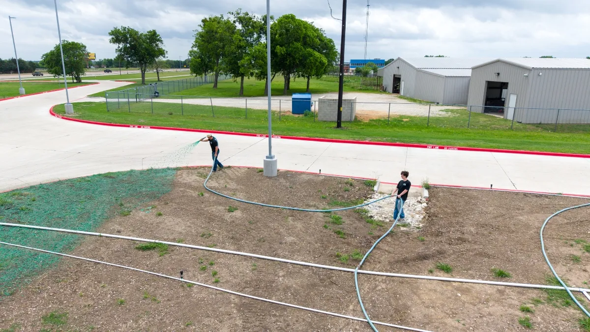 Hydroseeding application in progress along commercial property in North Texas