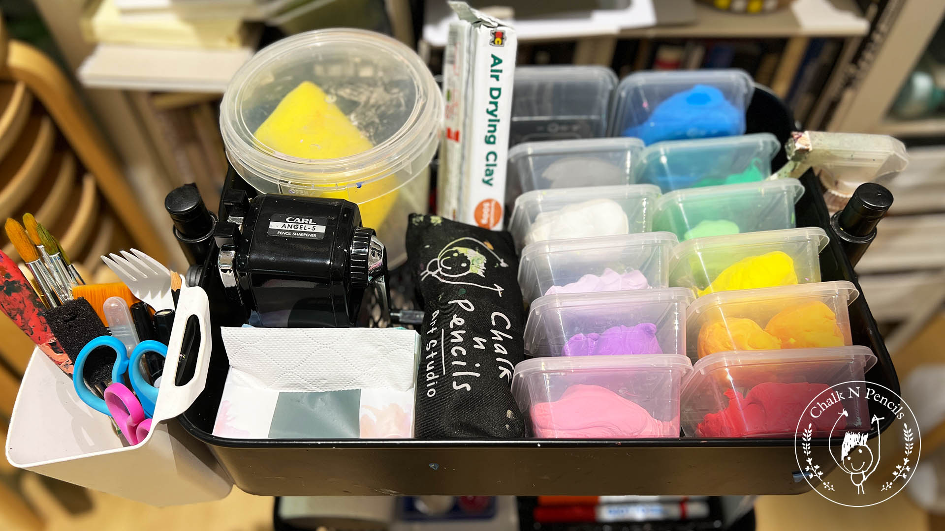 Top basket of the art trolley with markers, paper and a side caddy of pencils