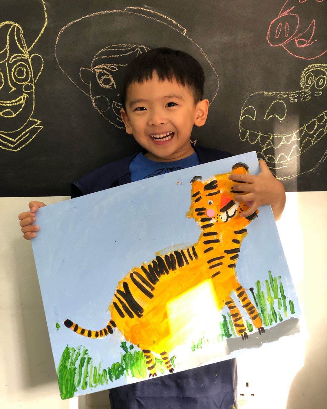 Young child painting a recognisable tiger