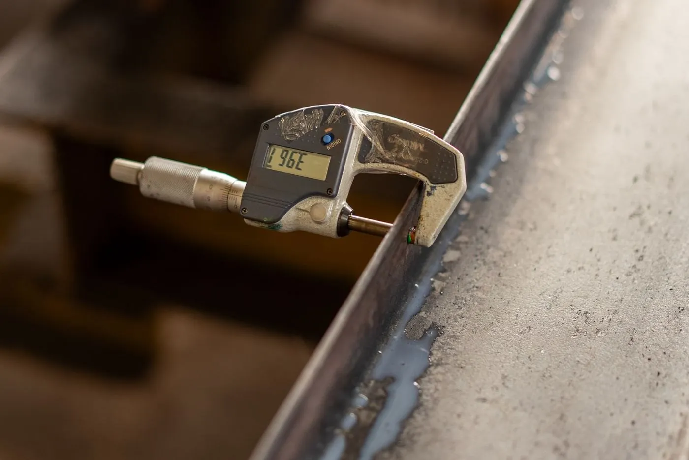 Digital micrometer measuring the thickness of a steel section