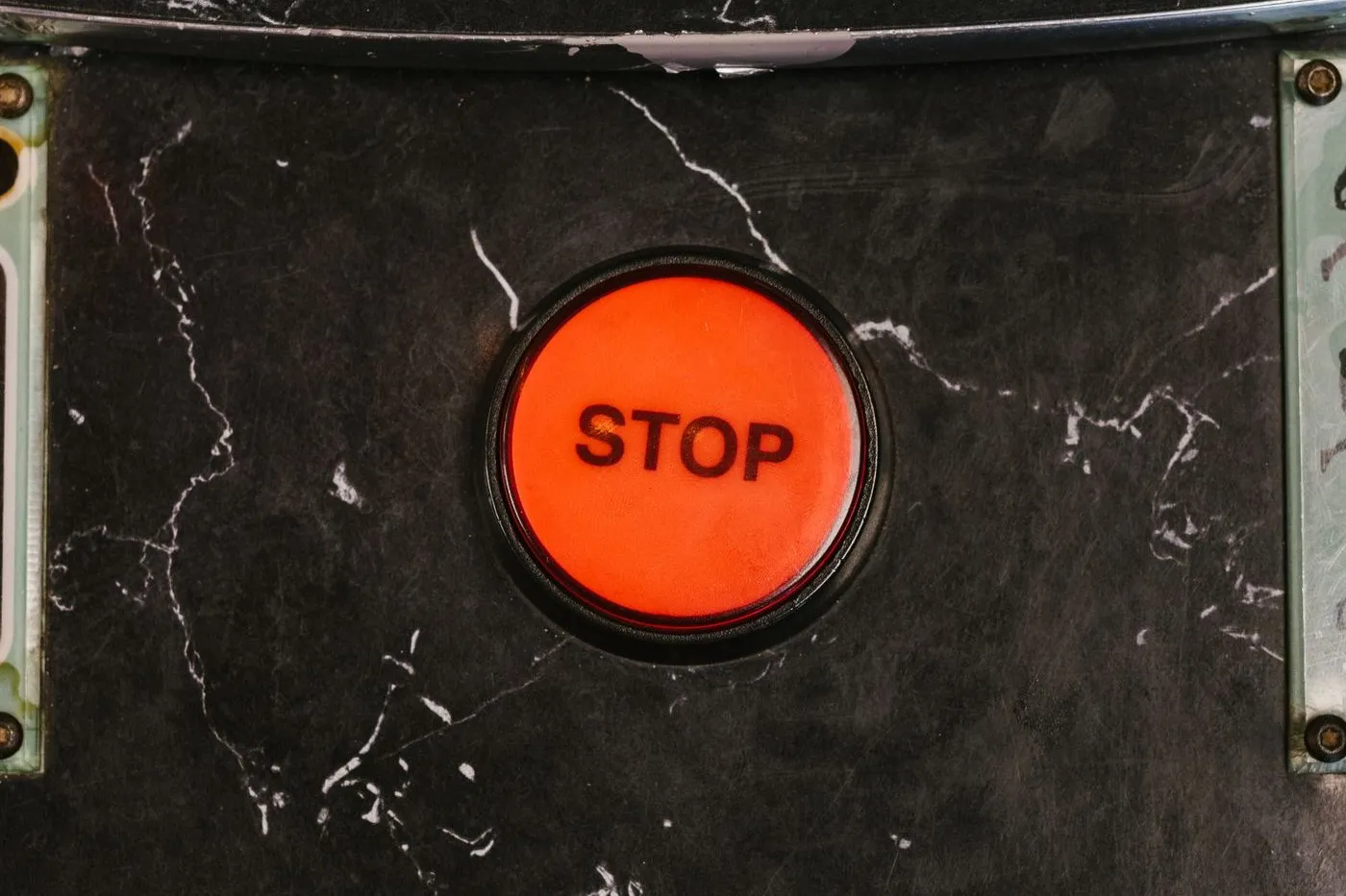 Red stop button on the control panel of an industrial machine
