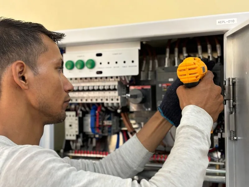 Technician wiring an industrial control cabinet