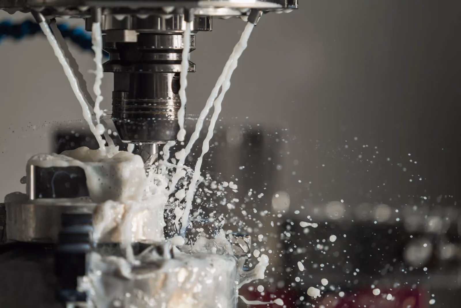 CNC cutter machining metal with coolant spraying across the tool