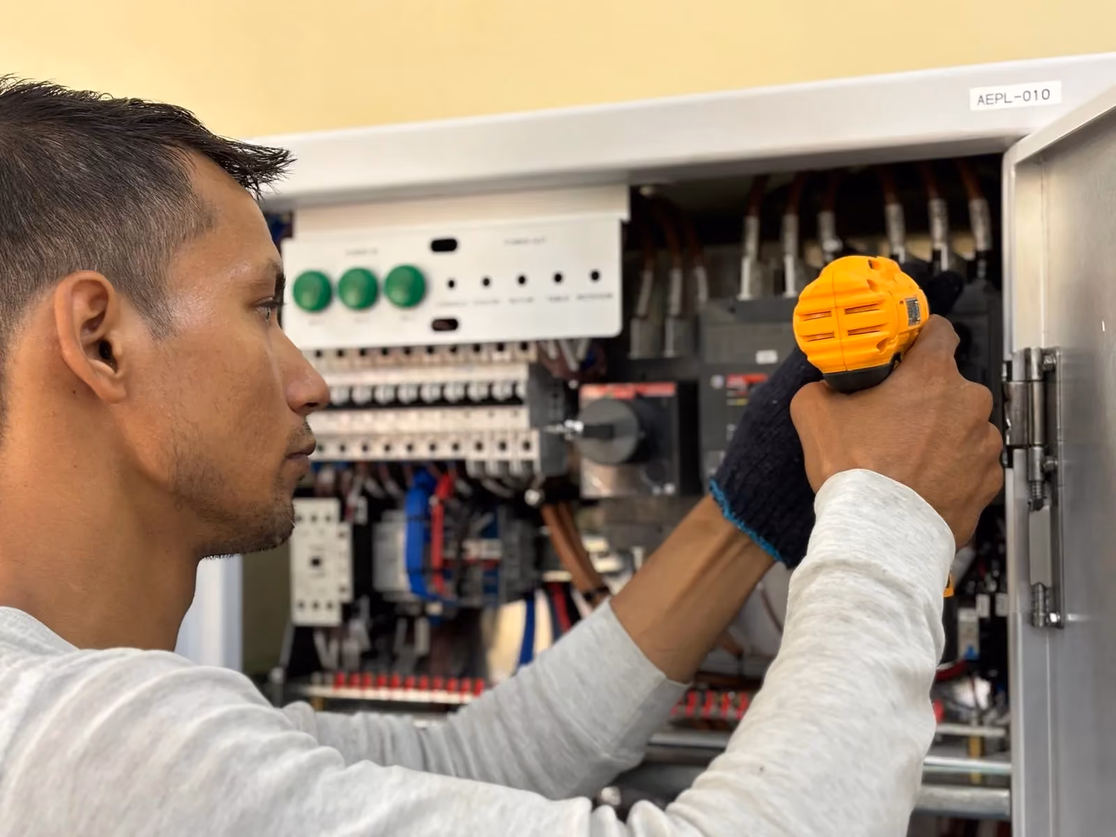 Technician wiring an open industrial control cabinet
