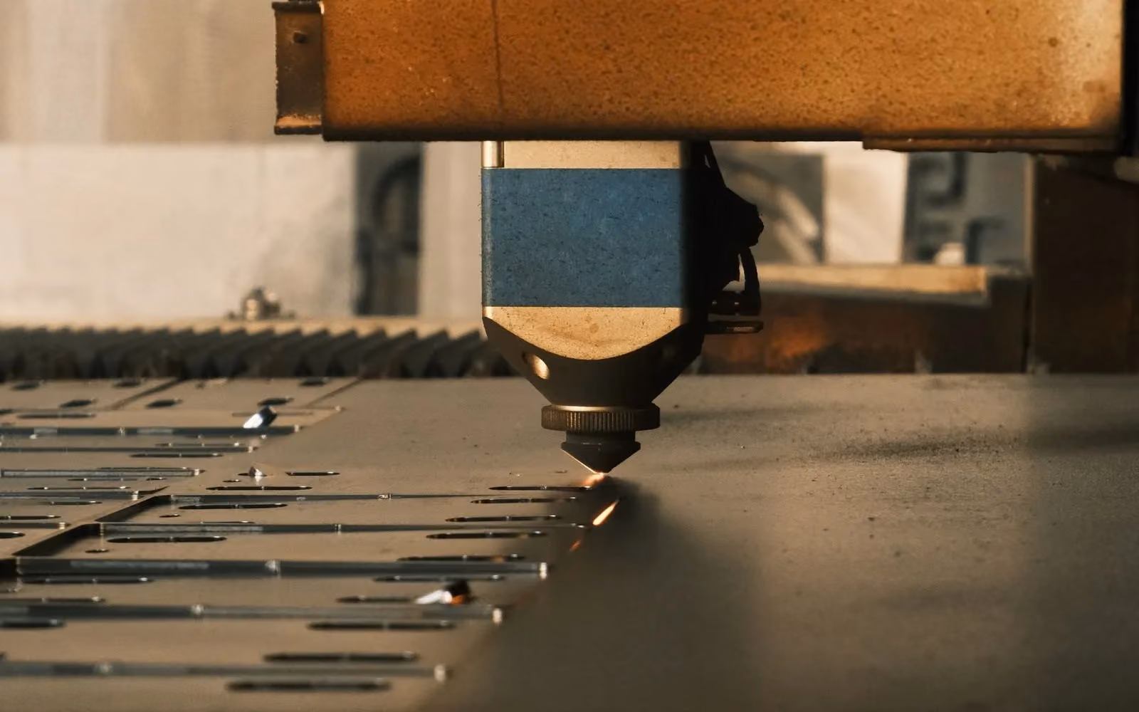 Cutting head working across sheet metal on a machine bed