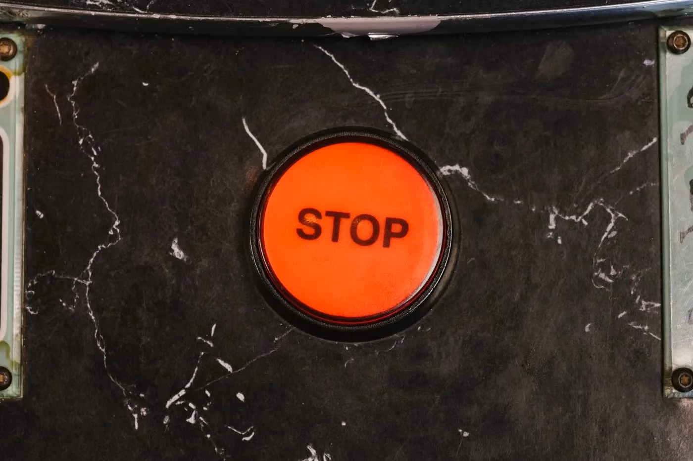 Red stop button on the control panel of an industrial machine