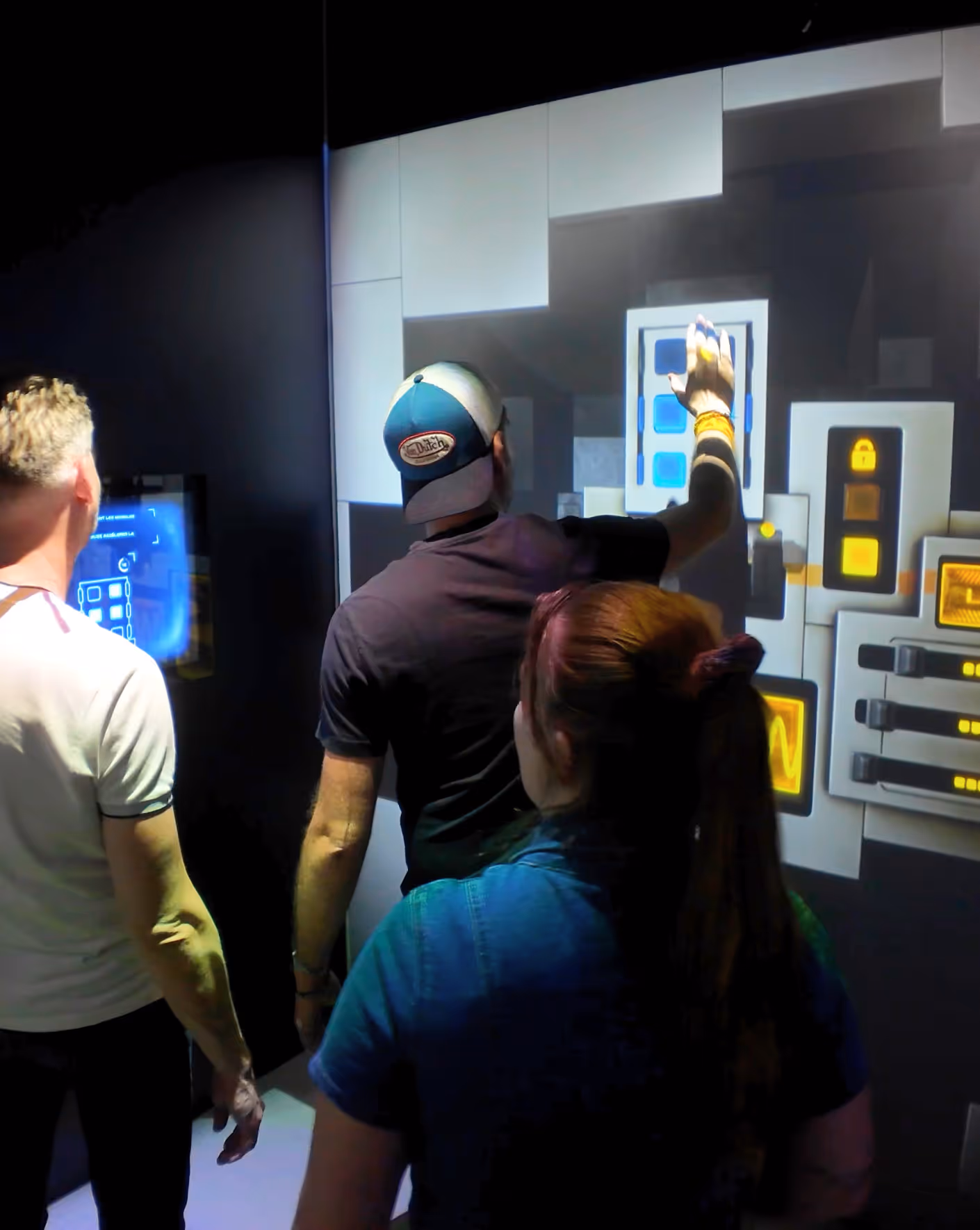 Joueurs coopérant devant le mur interactif de l'Infinity Room