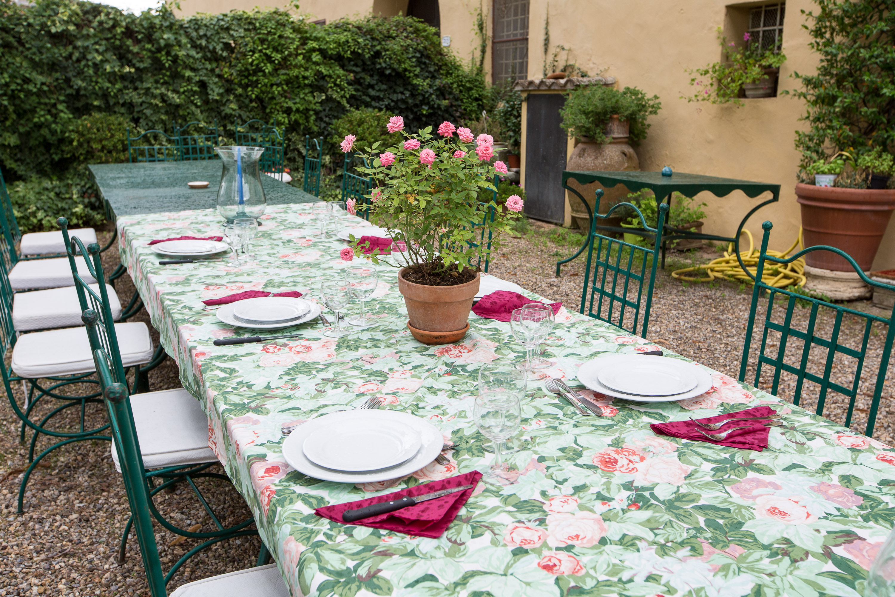 Small group enjoying a meal together outdoors under a shaded terrace roof.