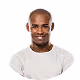 Smiling bald man with a beard wearing a white t-shirt against a yellow background.