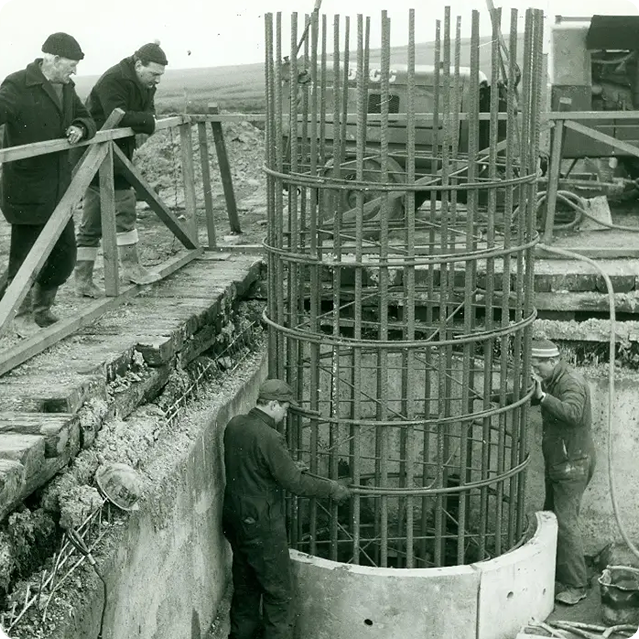 Engineers looking into a foundation pit for a transmitter mast. The image is black and white suggesting it is many years old