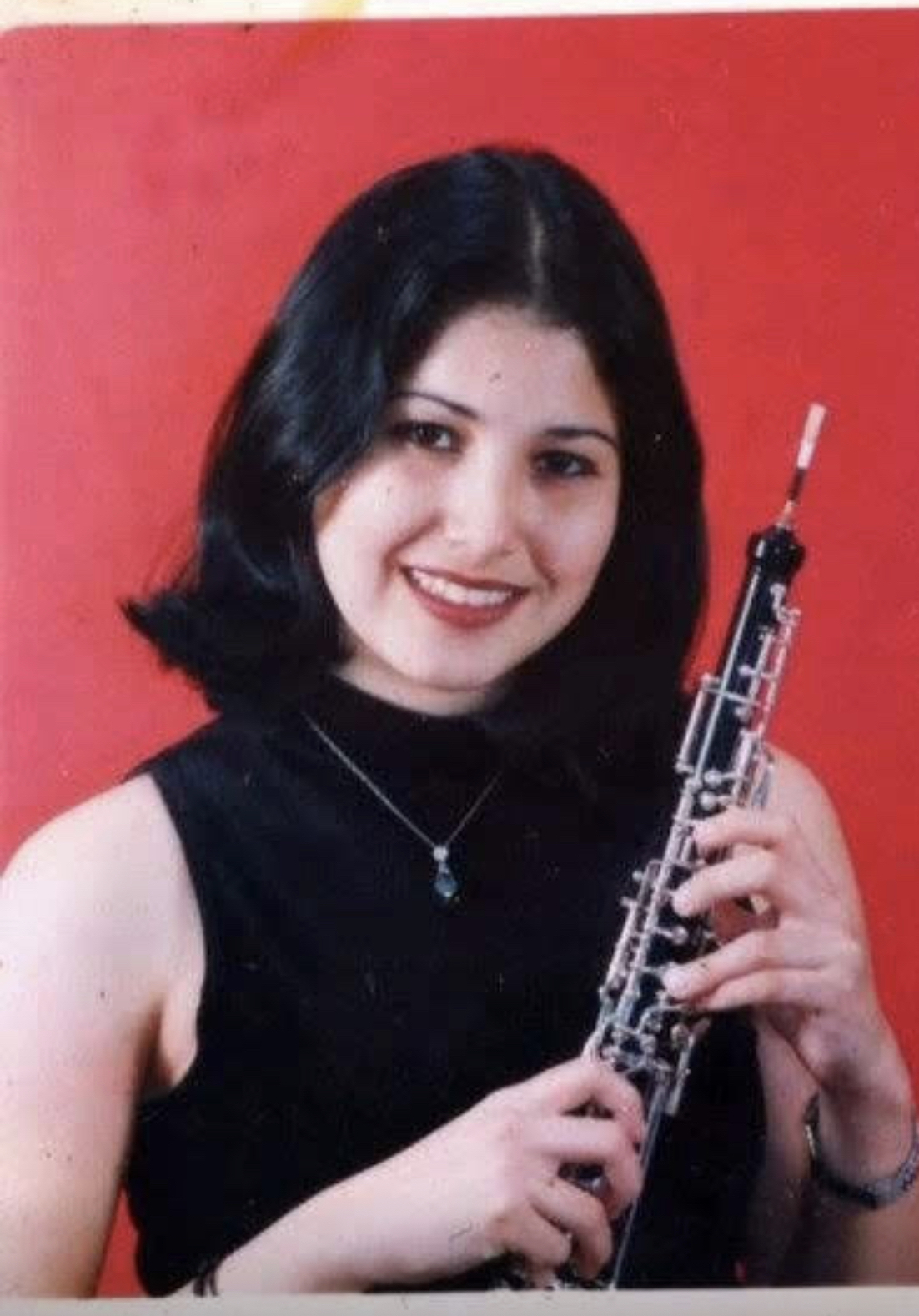 A young Nayli Russo holding her oboe in a portrait taken for her solo concerto.