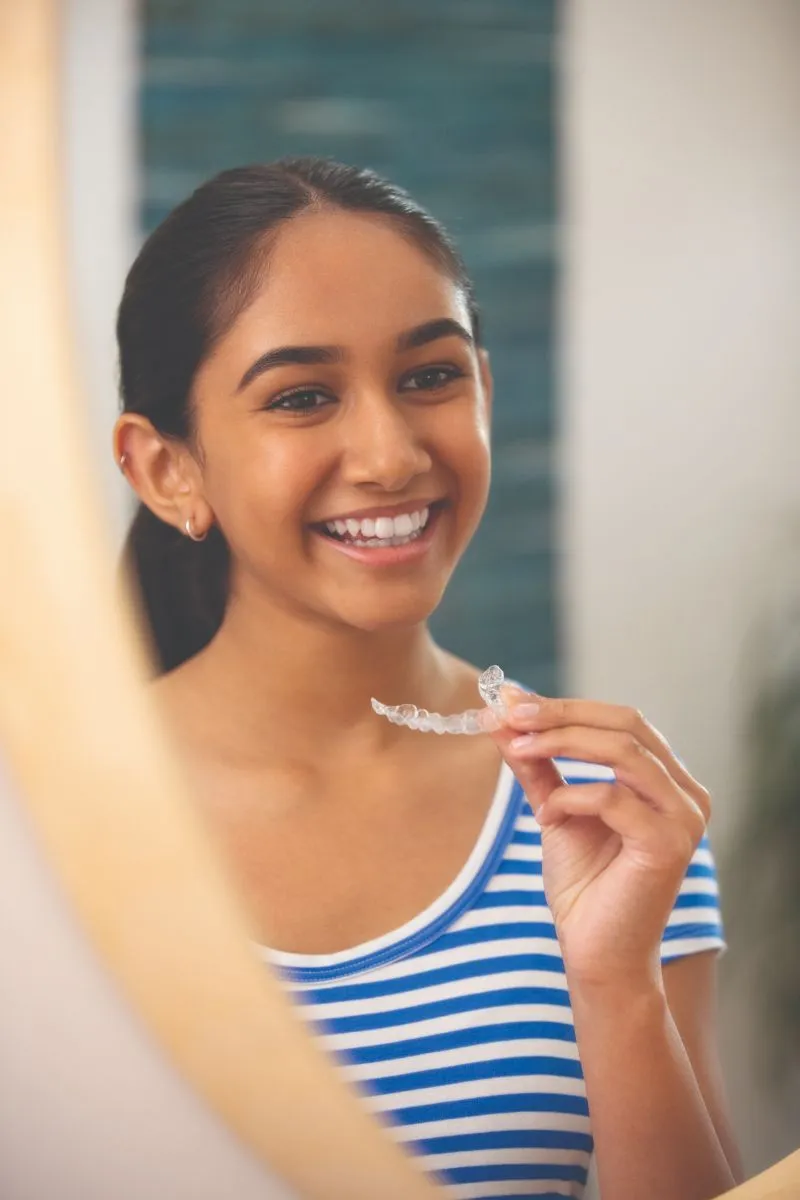 Teenager wearing clear Invisalign aligners instead of metal braces at Clarendon Dental Spa in Leeds