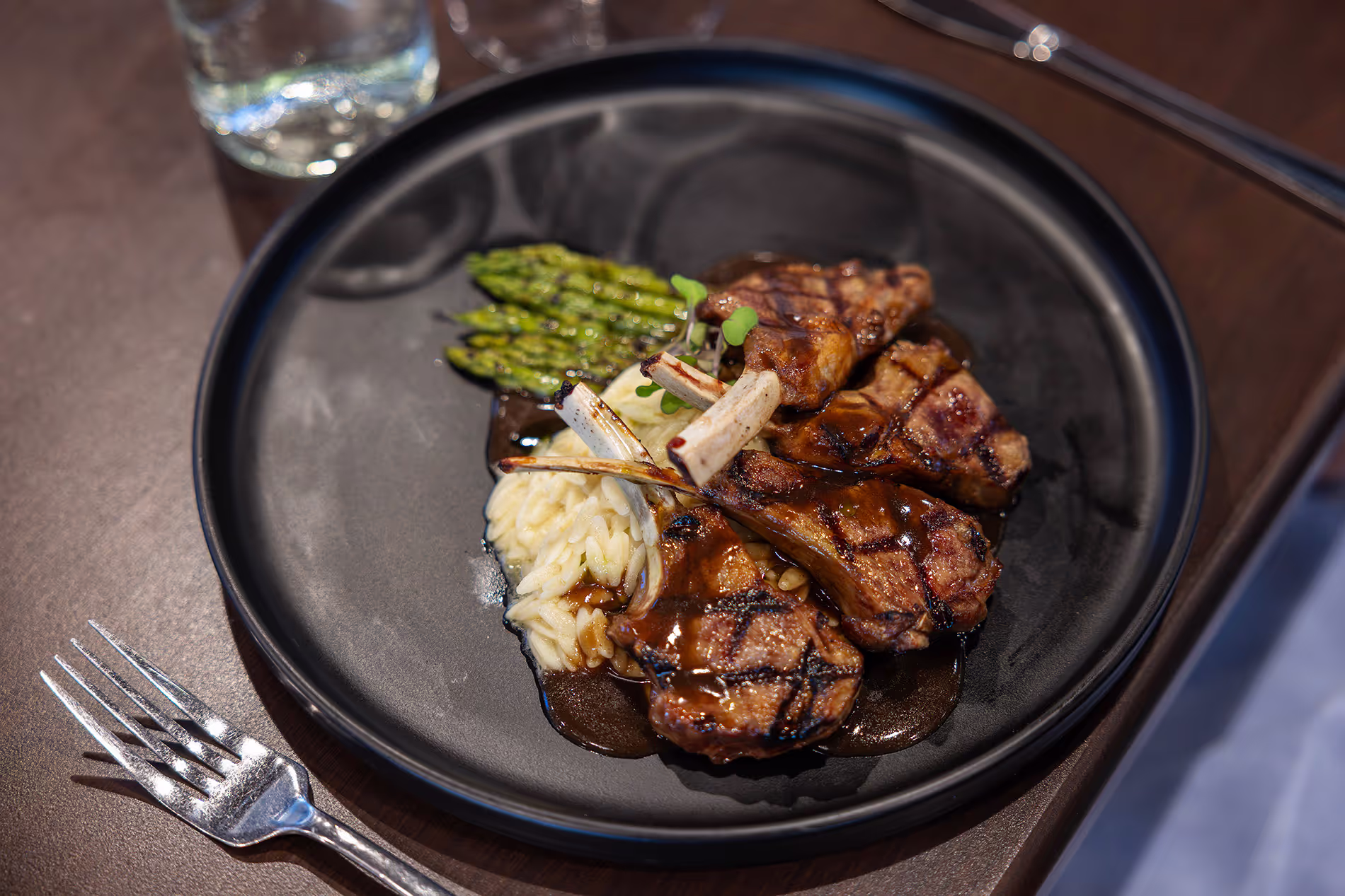 A beautifully plated dinner featuring steak, asparagus, and mashed potatoes, served with elegant presentation in a fine dining setting.
